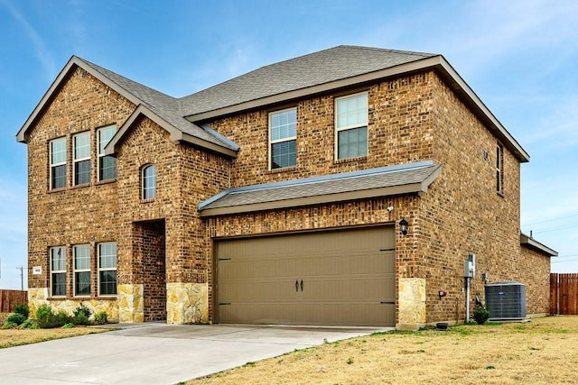 view of front facade featuring cooling unit, a garage, and a front yard