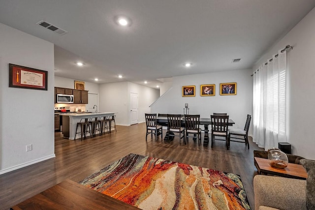 dining area with sink and dark wood-type flooring