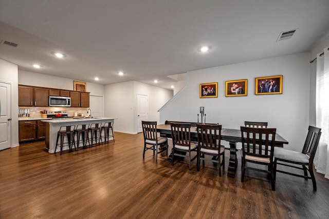 dining area with dark hardwood / wood-style flooring and sink