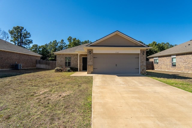 ranch-style home with a garage, a front yard, and central air condition unit