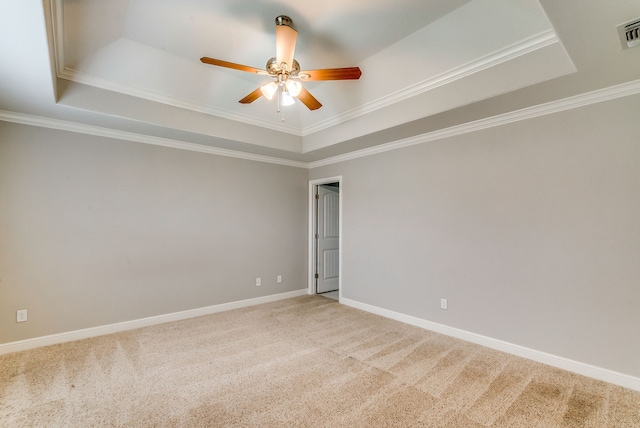 carpeted empty room with crown molding, ceiling fan, and a tray ceiling