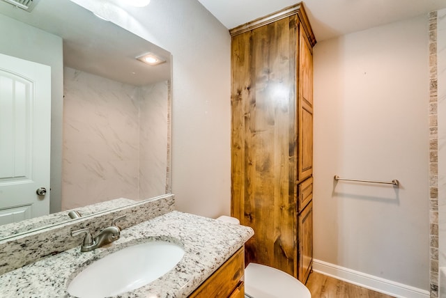 bathroom with hardwood / wood-style flooring, vanity, and toilet