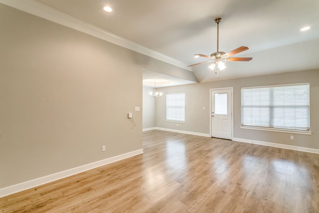 interior space featuring crown molding, vaulted ceiling, ceiling fan with notable chandelier, and light hardwood / wood-style flooring