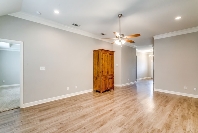 spare room with crown molding, vaulted ceiling, ceiling fan, and light hardwood / wood-style floors