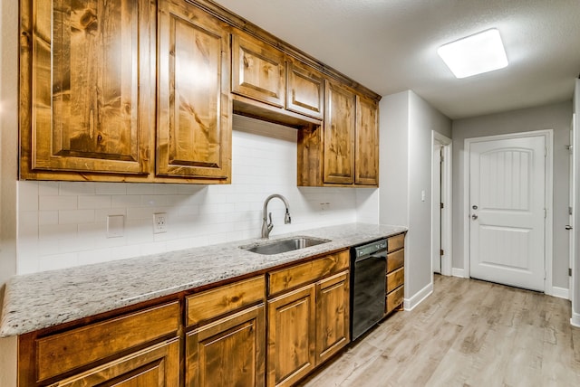 kitchen featuring sink, light stone counters, tasteful backsplash, light hardwood / wood-style flooring, and dishwasher