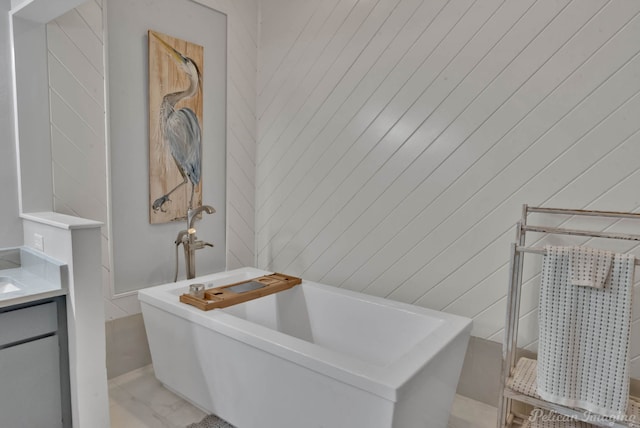 bathroom featuring a soaking tub and vanity