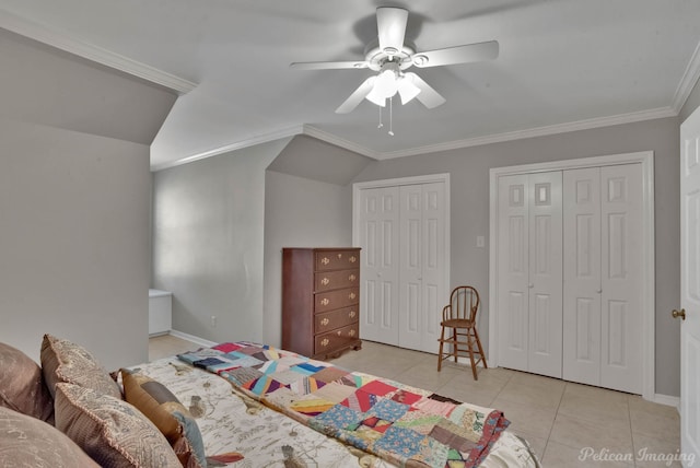 bedroom with light tile patterned flooring, crown molding, vaulted ceiling, two closets, and ceiling fan