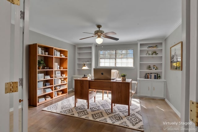 office area with light wood finished floors, baseboards, ceiling fan, ornamental molding, and built in shelves