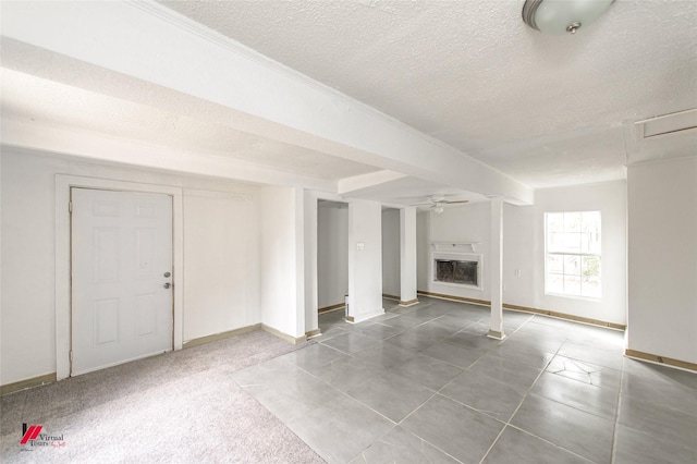 unfurnished living room featuring ceiling fan and a textured ceiling