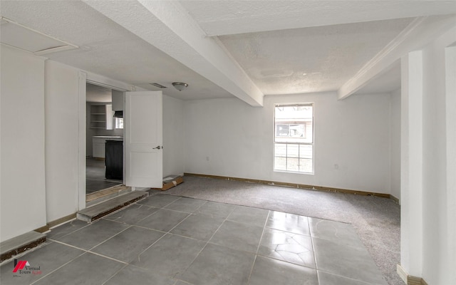 spare room featuring tile patterned flooring and a textured ceiling