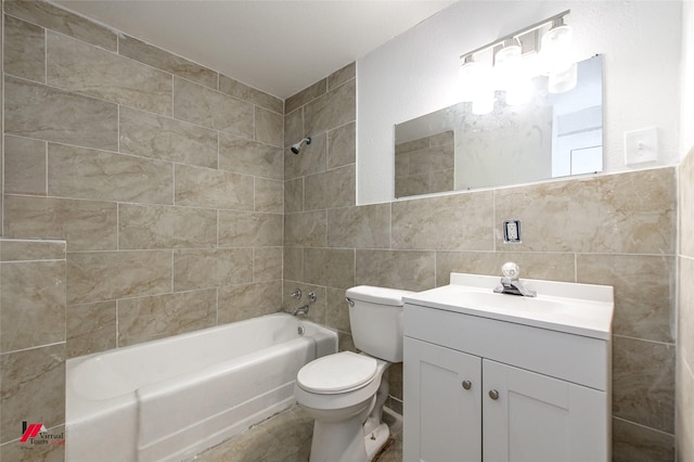 full bathroom with tiled shower / bath, vanity, toilet, and tile walls