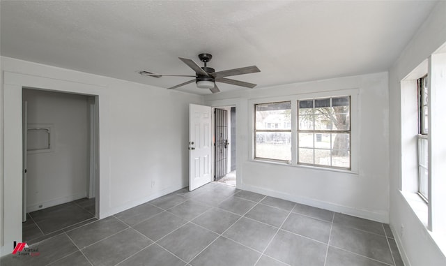 tiled empty room with a textured ceiling and ceiling fan