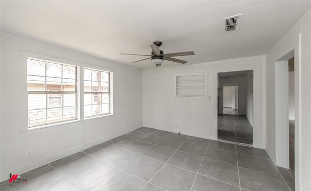 tiled spare room with ceiling fan