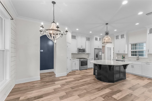 kitchen with a kitchen island, appliances with stainless steel finishes, a breakfast bar area, and white cabinets