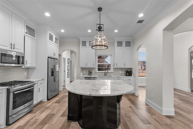 kitchen featuring sink, white cabinetry, light stone counters, a center island, and stainless steel appliances