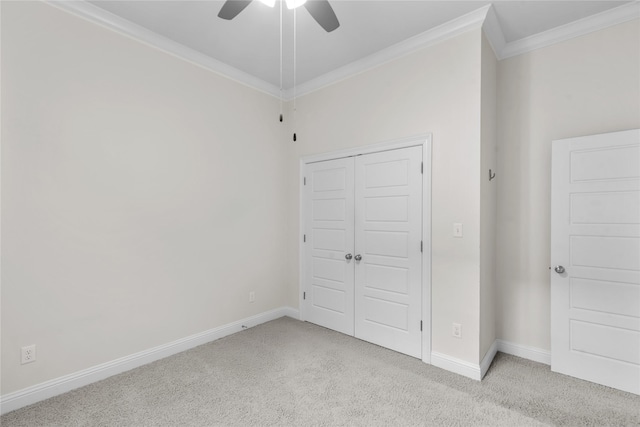 unfurnished bedroom with ceiling fan, light colored carpet, ornamental molding, and a closet