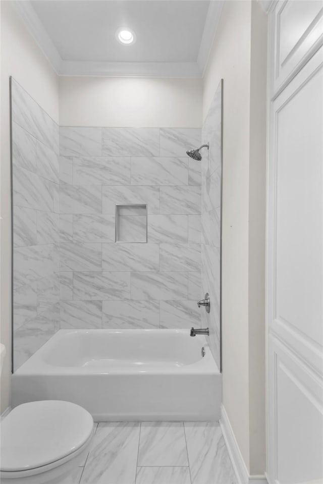 bathroom with tiled shower / bath combo, crown molding, and toilet