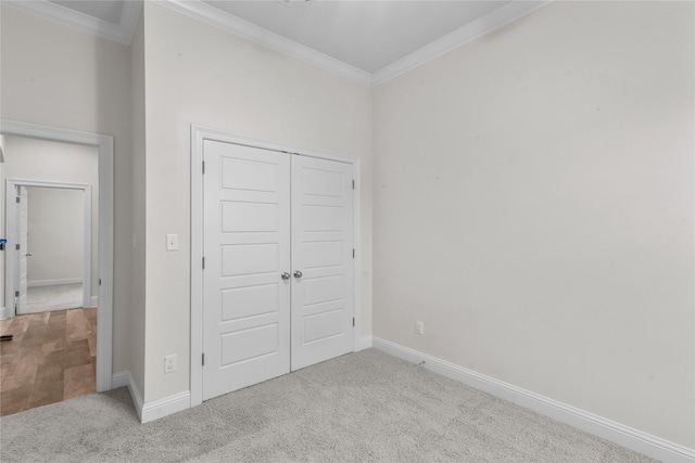 unfurnished bedroom featuring crown molding, a closet, and light carpet