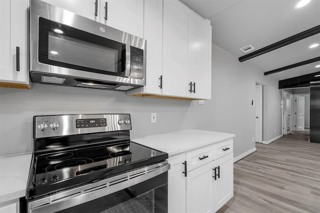 kitchen featuring stainless steel appliances, white cabinets, and light hardwood / wood-style flooring