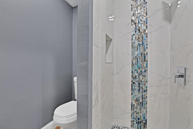 bathroom featuring toilet and tiled shower