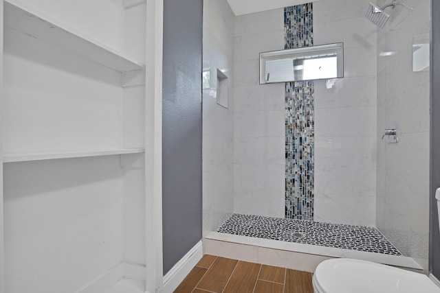 bathroom featuring toilet and tiled shower