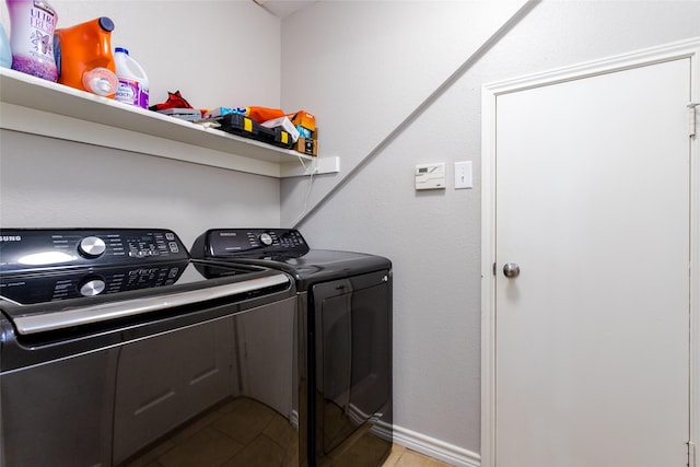 clothes washing area with laundry area, light tile patterned floors, and washer and clothes dryer