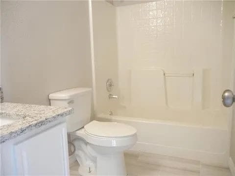 full bathroom with bathing tub / shower combination, vanity, and toilet