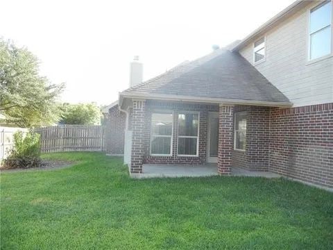 rear view of house with a patio area and a lawn