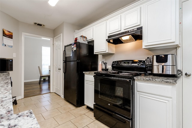 kitchen with visible vents, light stone counters, under cabinet range hood, black appliances, and white cabinetry