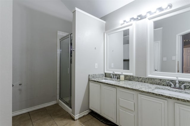 full bathroom with a stall shower, tile patterned flooring, a sink, and double vanity