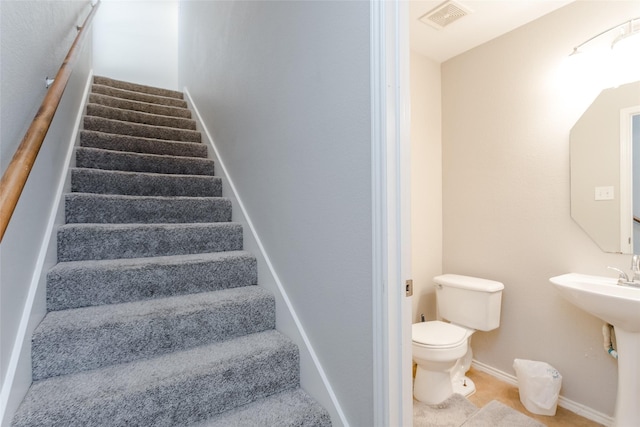 staircase featuring baseboards and visible vents