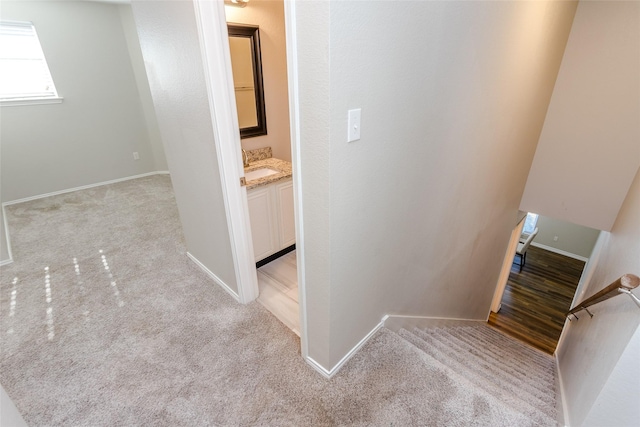 corridor with light carpet and baseboards