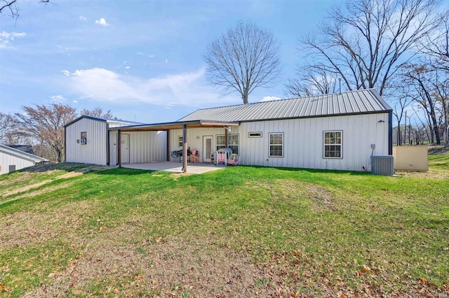 rear view of property with central AC, a patio area, and a lawn