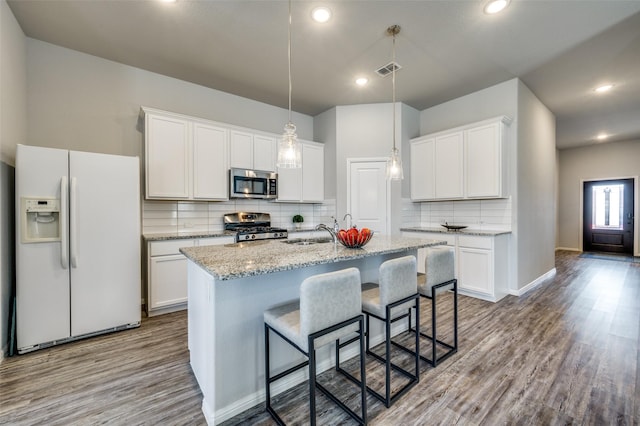 kitchen featuring white cabinetry, appliances with stainless steel finishes, and a kitchen island with sink