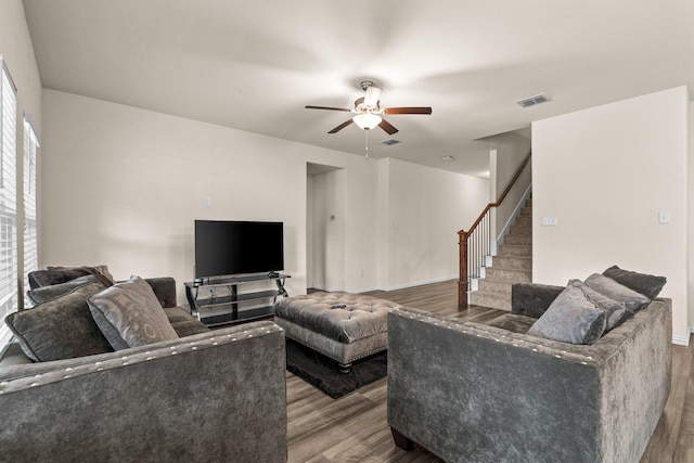 living room featuring wood-type flooring and ceiling fan