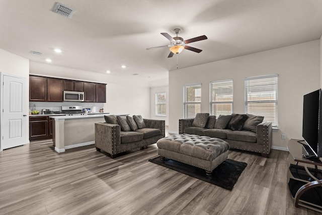 living room featuring ceiling fan and light hardwood / wood-style floors