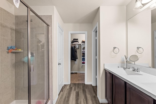 bathroom with wood-type flooring, an enclosed shower, and vanity