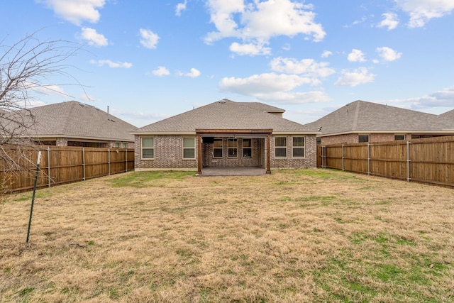 rear view of property featuring a yard and a patio