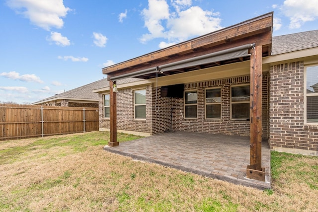 back of property with a lawn and a patio