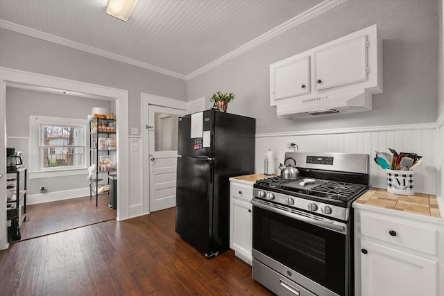 kitchen featuring white cabinetry, dark hardwood / wood-style floors, stainless steel gas range oven, ornamental molding, and black fridge