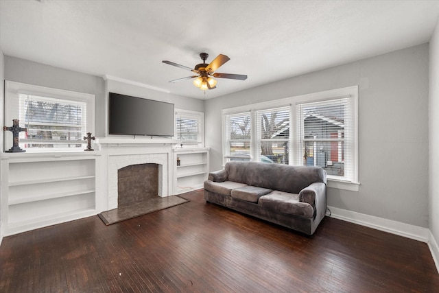 living room featuring a brick fireplace, hardwood / wood-style floors, and ceiling fan