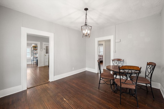 dining space featuring an inviting chandelier and dark hardwood / wood-style floors