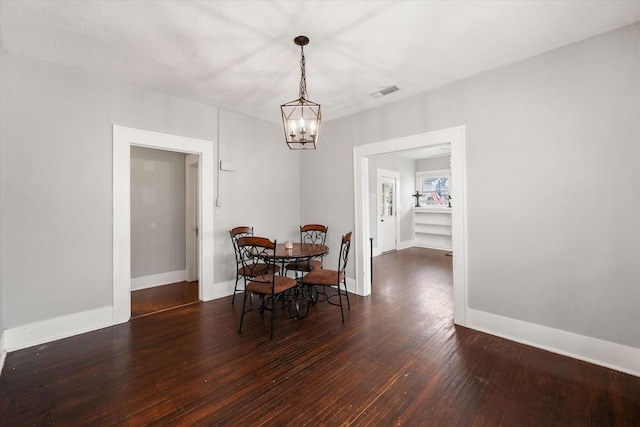 dining area with dark hardwood / wood-style floors and a chandelier