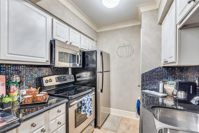 kitchen featuring appliances with stainless steel finishes, white cabinetry, sink, decorative backsplash, and crown molding