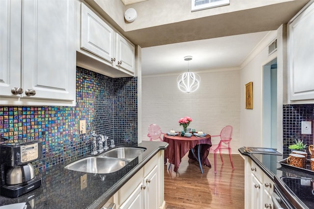 kitchen with white cabinetry, sink, and decorative light fixtures