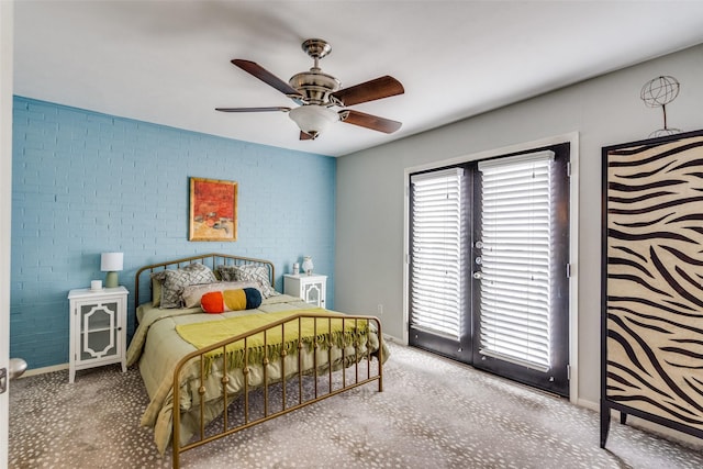 bedroom with access to exterior, ceiling fan, and brick wall