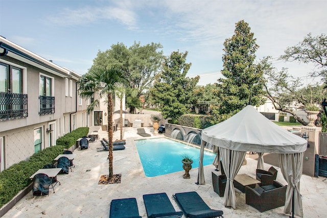 view of pool with a patio and pool water feature