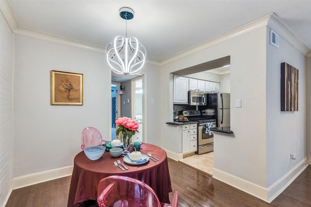 dining space with an inviting chandelier, crown molding, and light hardwood / wood-style floors