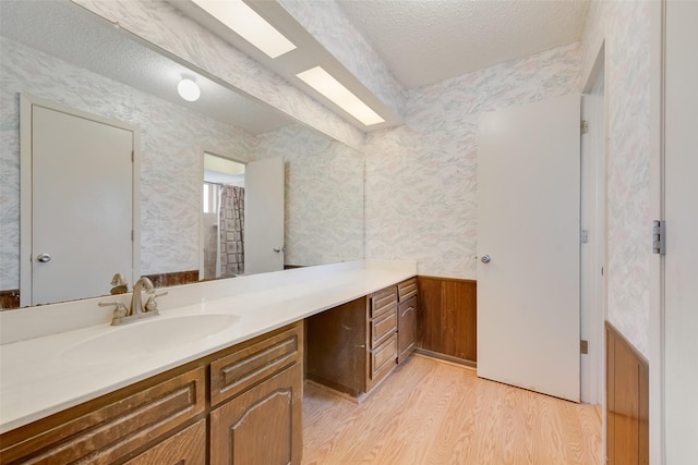 bathroom with vanity, hardwood / wood-style floors, and a textured ceiling