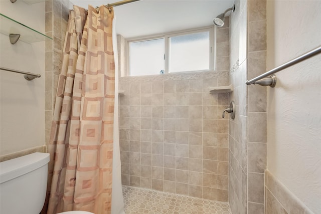 bathroom featuring a shower with curtain and toilet